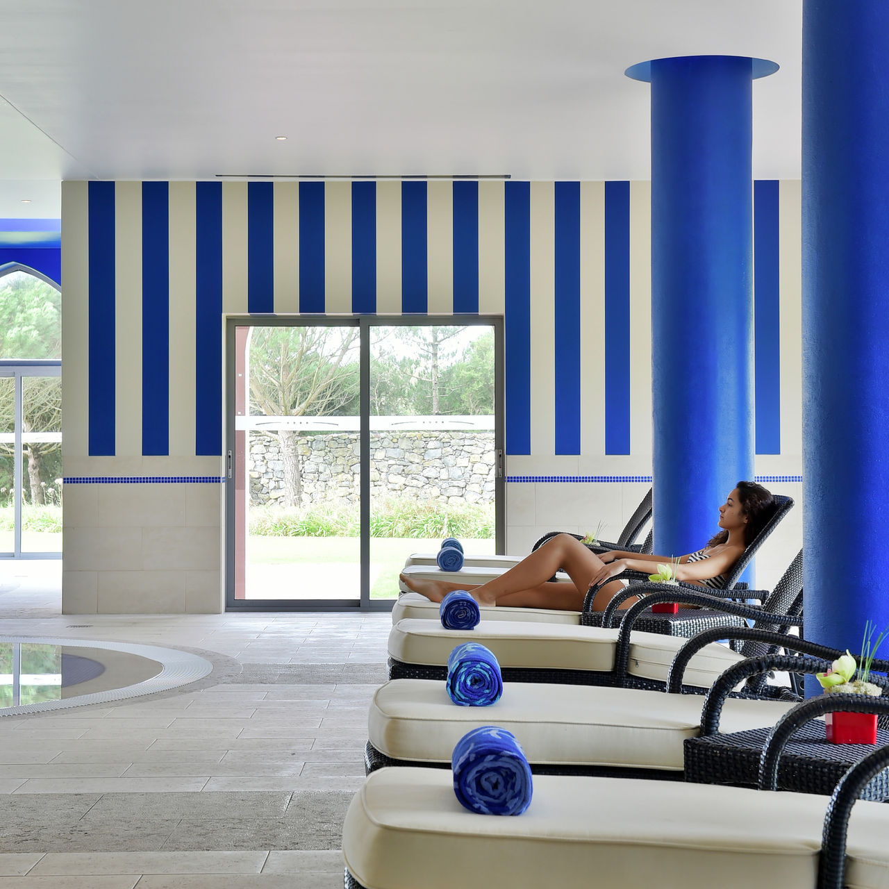 Piscina interior del Pestana Sintra Golf, Hotel de 4 Estrellas en Sintra, con tumbonas acolchadas y toallas azules