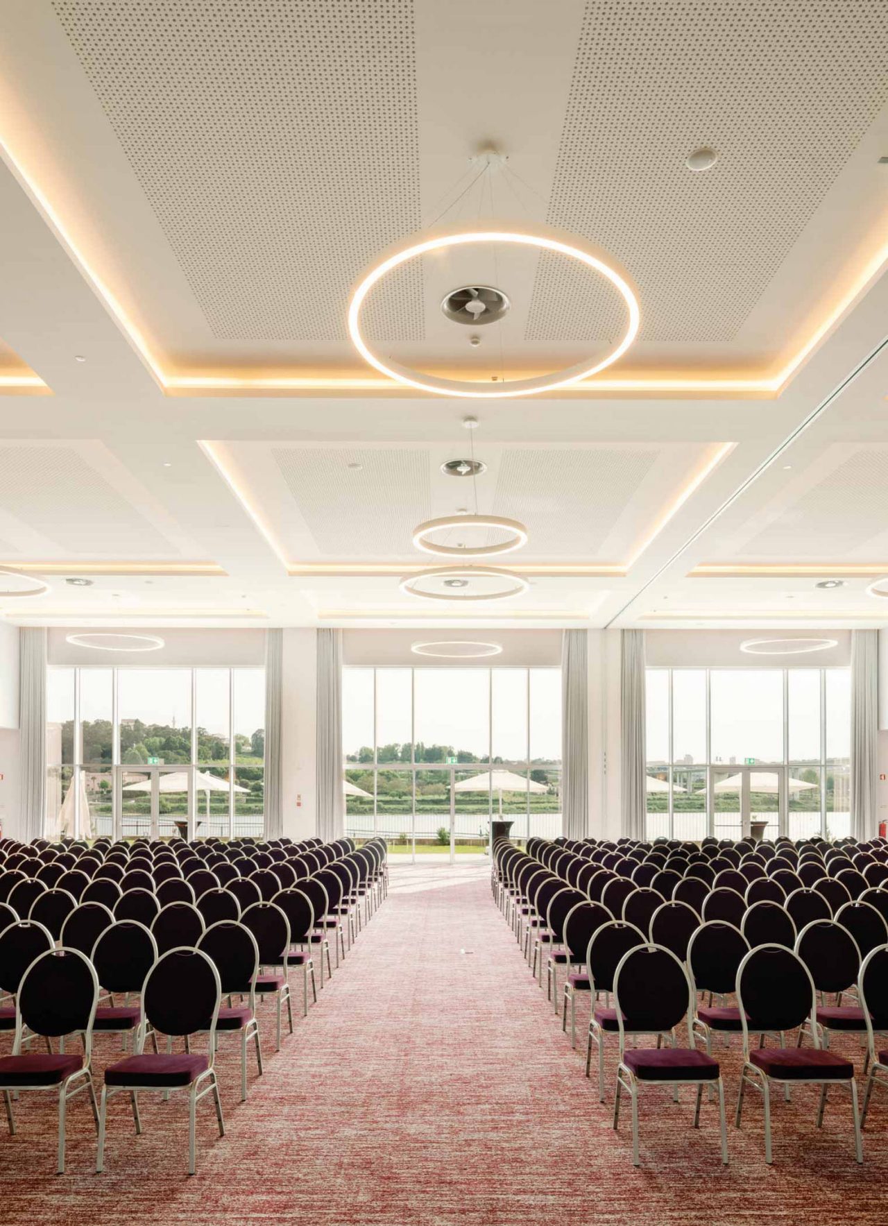 Espacio para reuniones o conferencias, en una sala amplia con varias sillas y ventanas que permiten la luz natural
