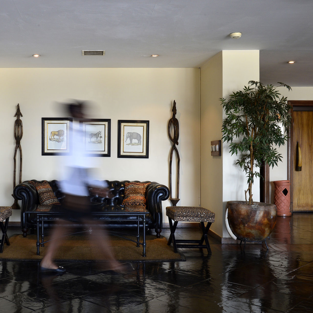 Lobby com um sofá preto e dois vasos com decoração típica africana do Pestana Rovuma, um hotel 4 estrelas em Maputo