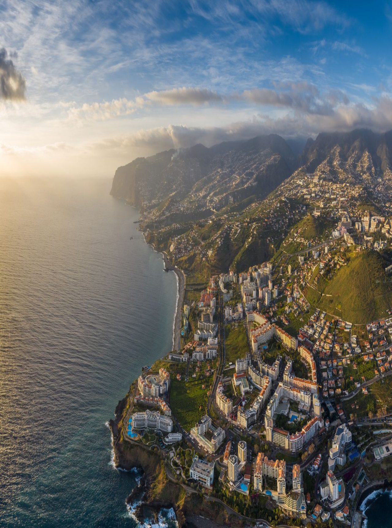 Vista aérea da cidade do Funchal, na Madeira, com áreas urbanas densas e montanhas ao fundo