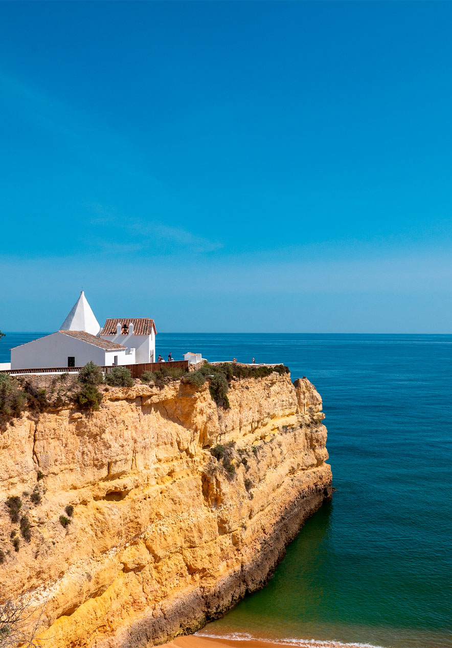 Capela Nossa Senhora da Rocha, um santuário branco no topo de um penhasco e com vista para o oceano Atlântico