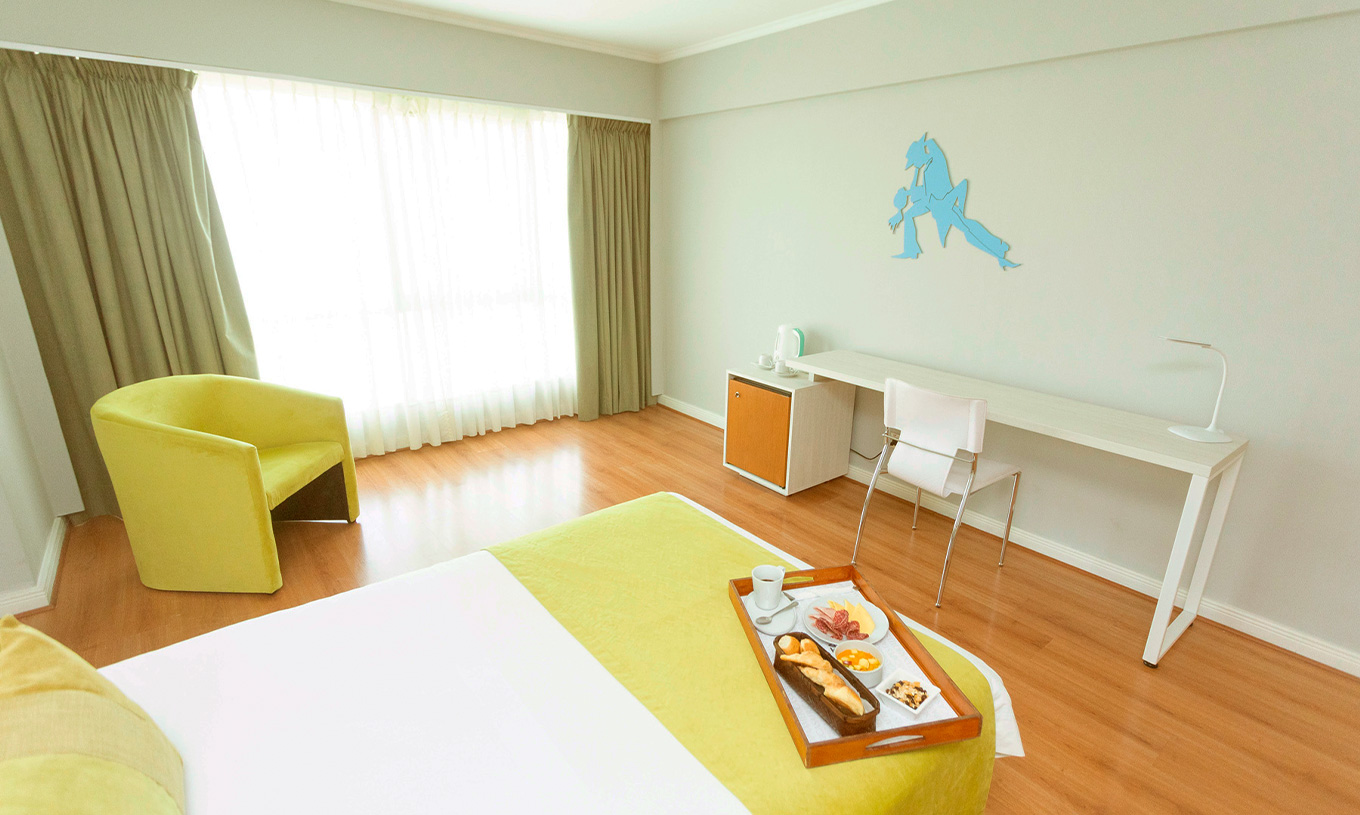 Das Queen Executive Zimmer im Pestana Buenos Aires hat einen Stuhl, einen Schreibtisch und dekorative Elemente