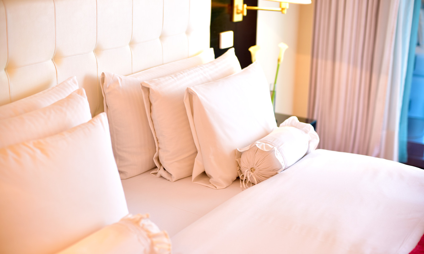 Das Queen Superior Zimmer im Pestana Buenos Aires hat ein Doppelbett mit verschiedenen Kissenarten