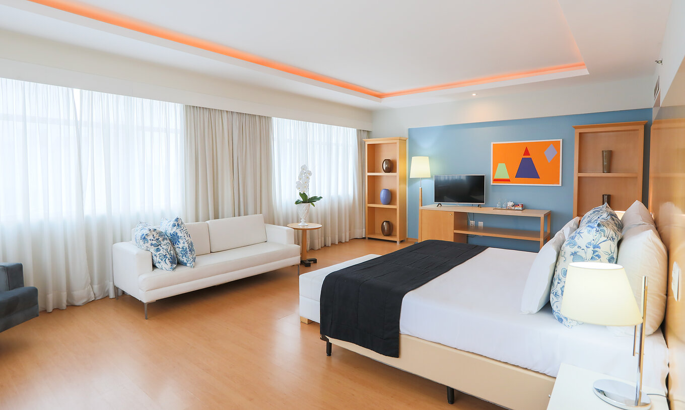 Die Executive Suite im Pestana Curitiba ist ein geräumiges Zimmer mit vielen Fenstern, hell, mit Doppelbett und Sofa