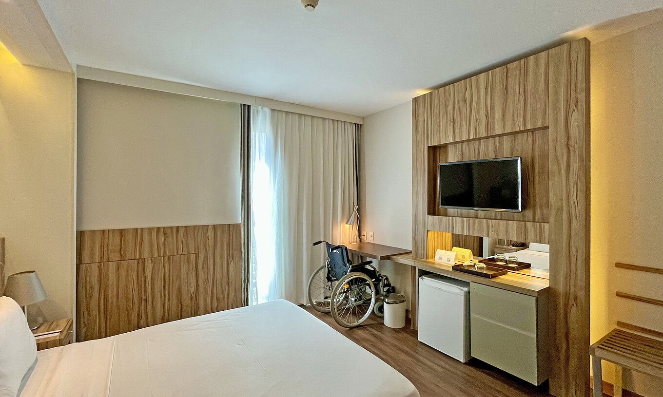 Das Queen Adaptiert Standard hat ein Doppelbett und einen Schreibtisch mit einem Rollstuhl 