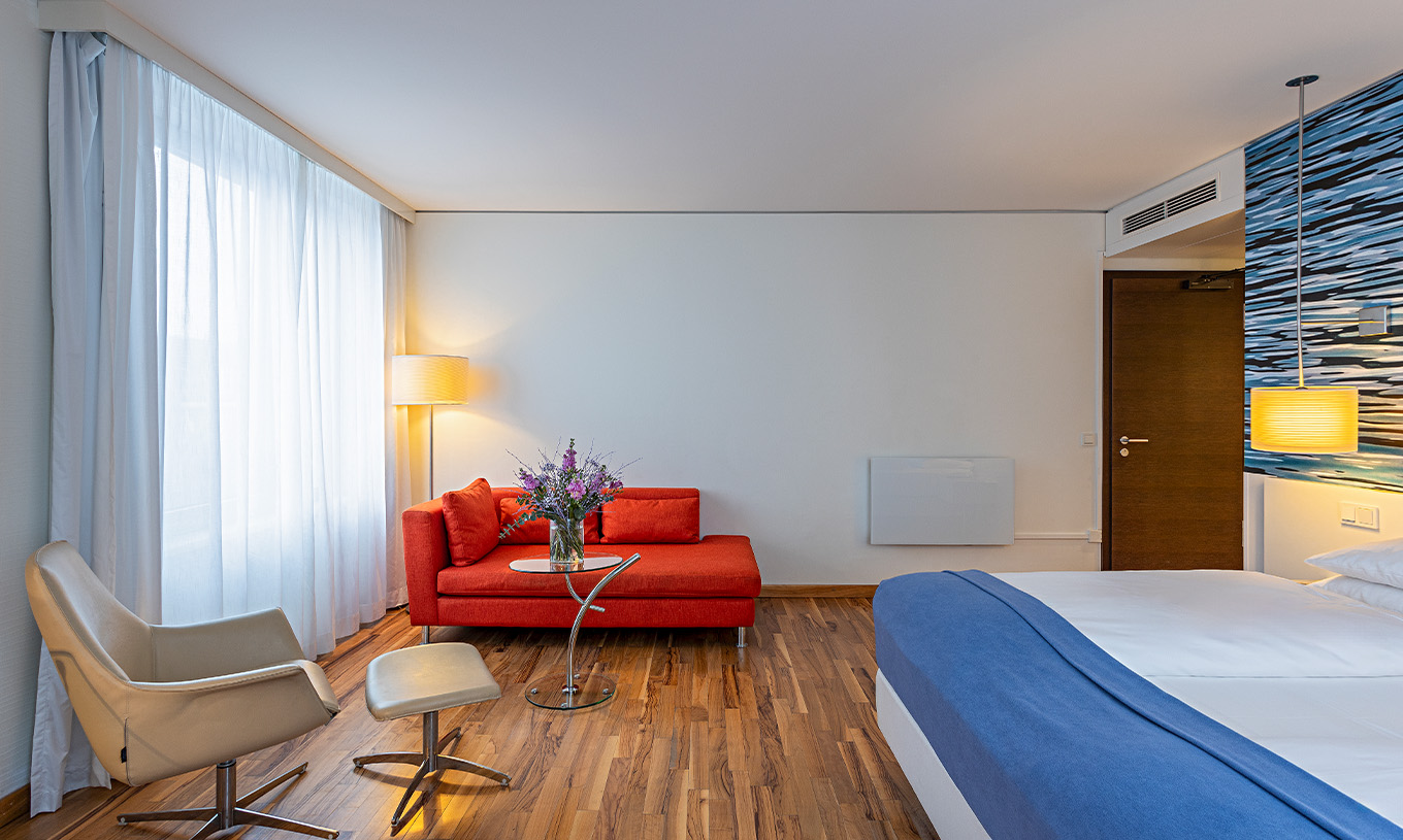 Das Grand Deluxe Zimmer im Pestana Berlin Tiergarten hat ein Doppelbett, ein Sofa, einen Couchtisch und einen Sessel
