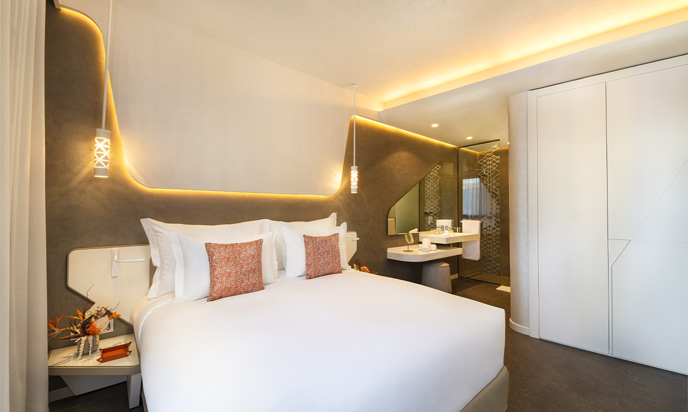 Die CR7 Junior Suite im Pestana CR7 Marrakeck hat ein großes Doppelbett, Lichter an der Wand und Bad im Zimmer