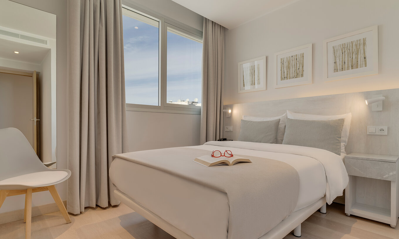 Die Familien-Suite im Pestana Tanger City Center hat ein Doppelbett mit Stein-Kopfteil, ein Fenster und einen Stuhl