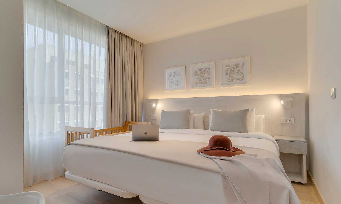 Die Suite im Pestana Tanger City Center hat ein Doppelbett mit Stein-Kopfteil, ein Kinderbett und ein Fenster