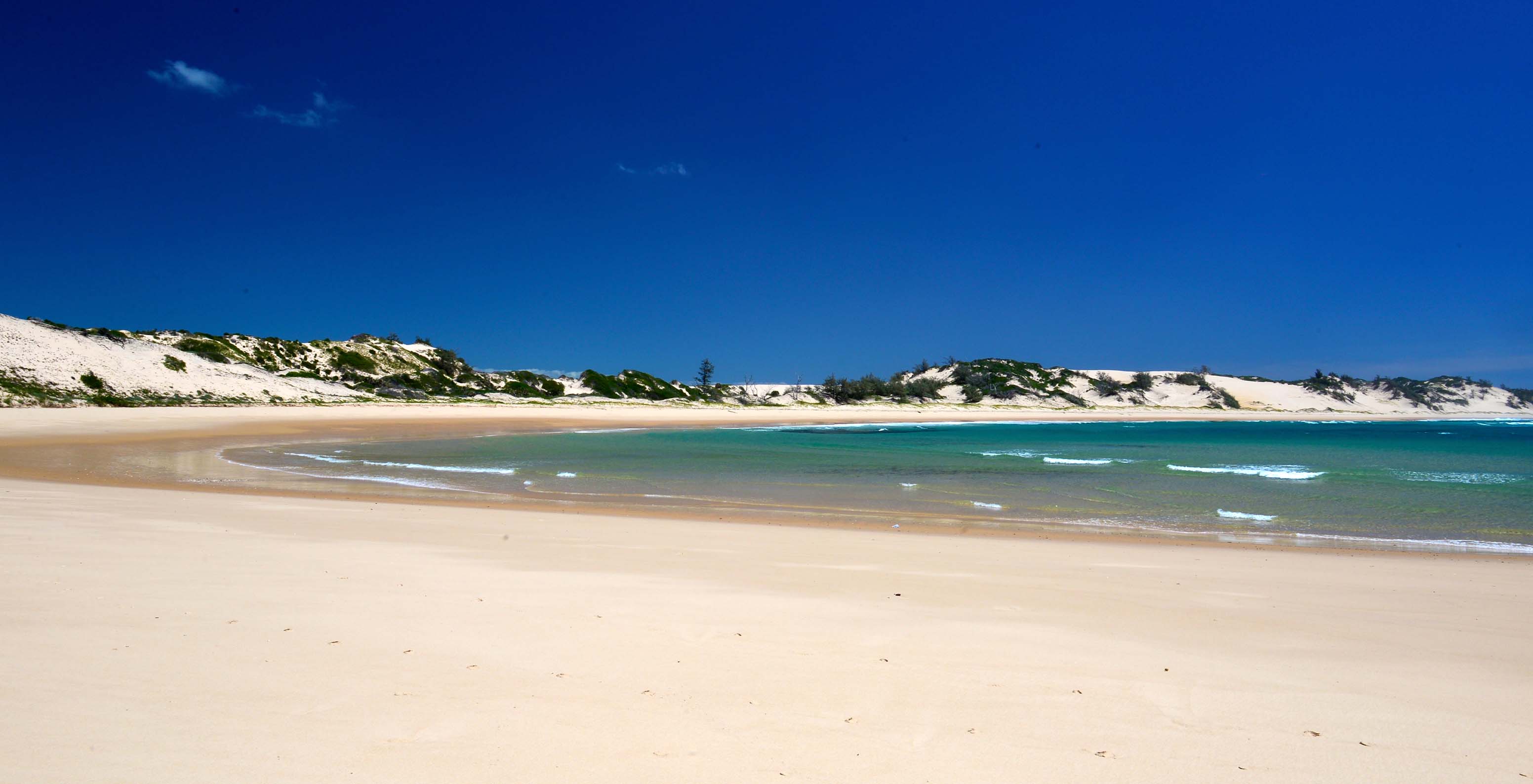 Einsame Strand auf der Insel Bazaruto, die eine kleine Bucht mit weißem Sand und kristallblauem Wasser bildet