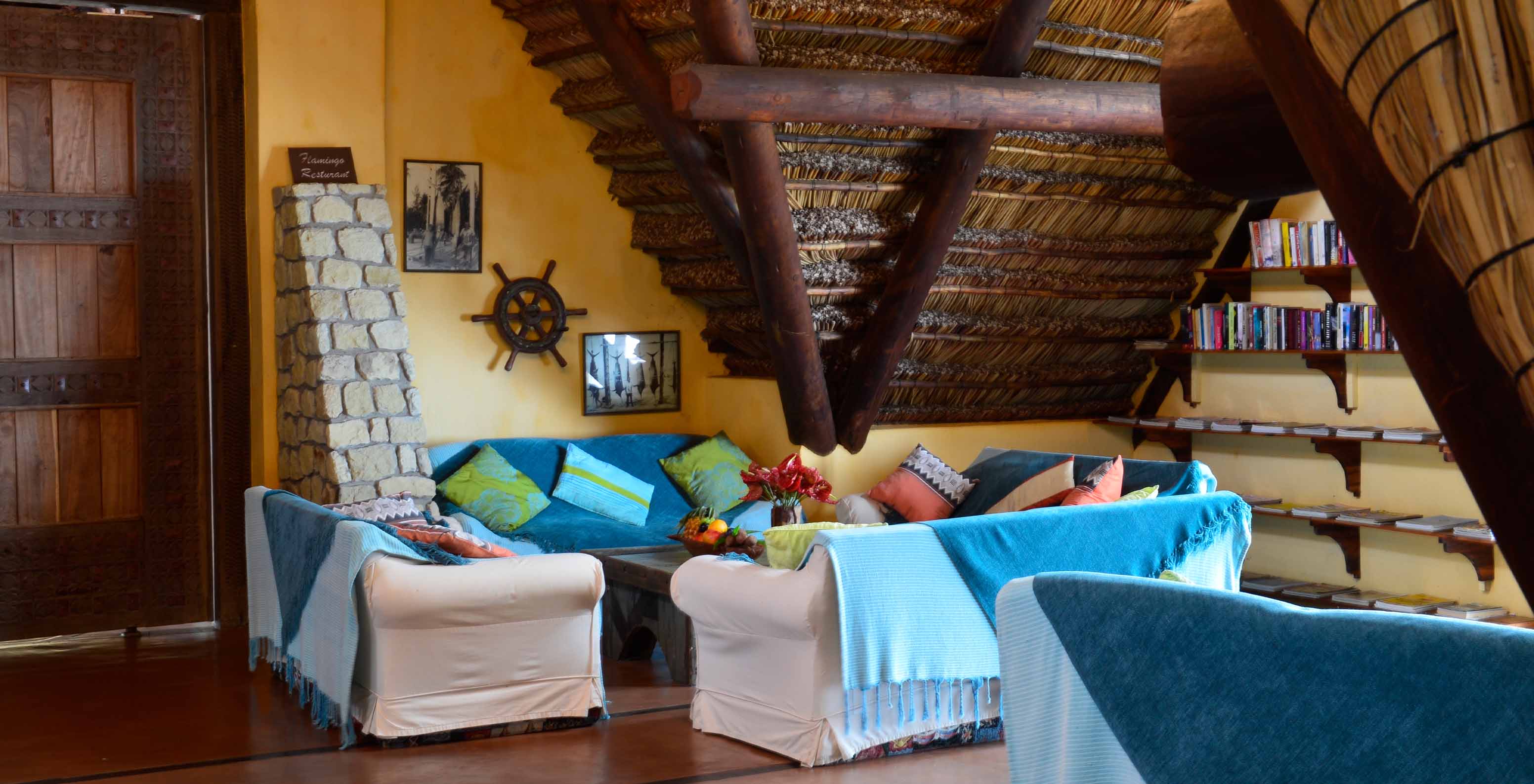 Die Bungalow Suite T2 im Pestana Bazaruto Lodge hat ein geräumiges Zimmer mit Sofas mit blauen Decken und bunten Kissen