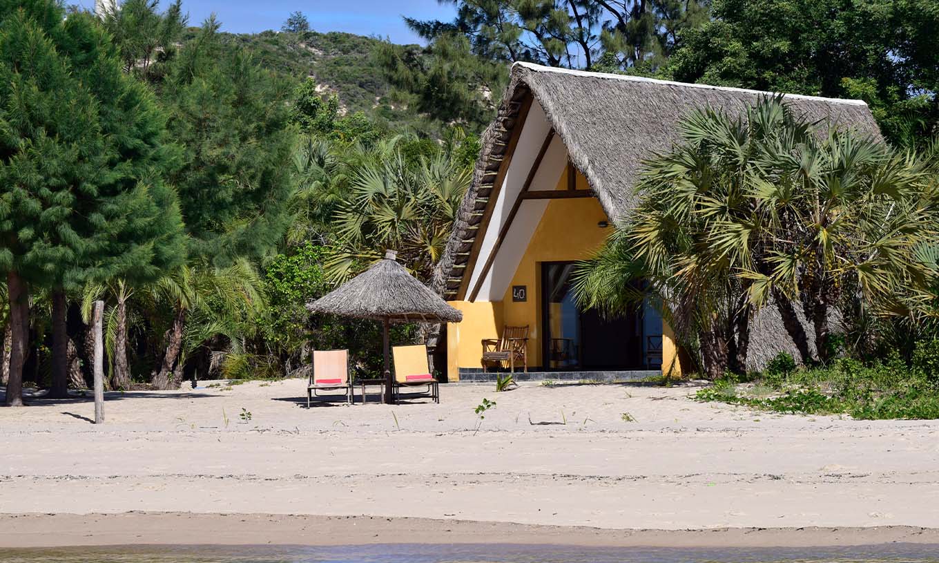 Die Bungalow Suite T2 im Pestana Bazaruto Lodge ist ein Häuschen mit einem Strohdach am Strand in üppiger Natur