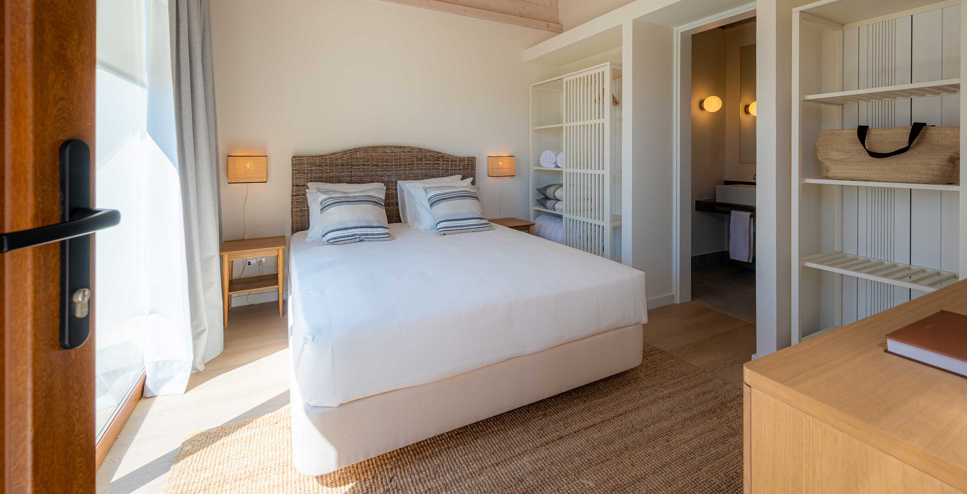Die Standard Villa im Pestana Comporta Village Residences hat ein Schlafzimmer mit Doppelbett und schlichter Dekoration