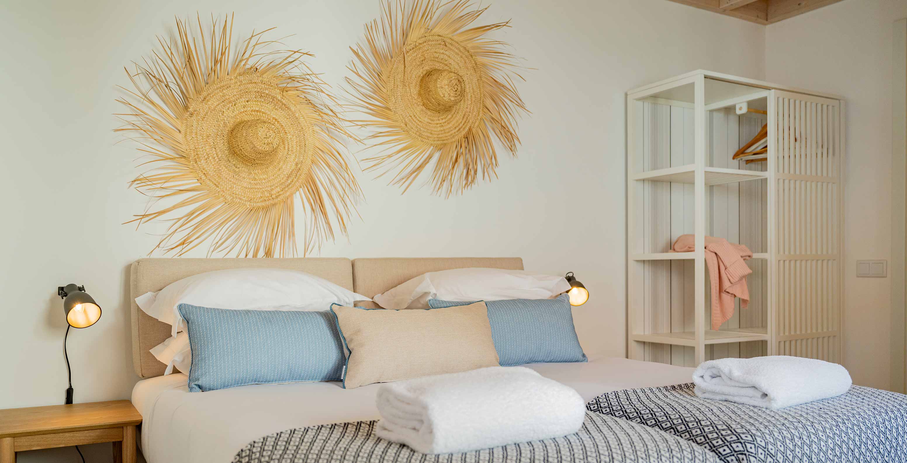 Die Superior Villa im Pestana Comporta Village Residences verfügt über ein Doppelbett mit Strohdekoration an der Wand