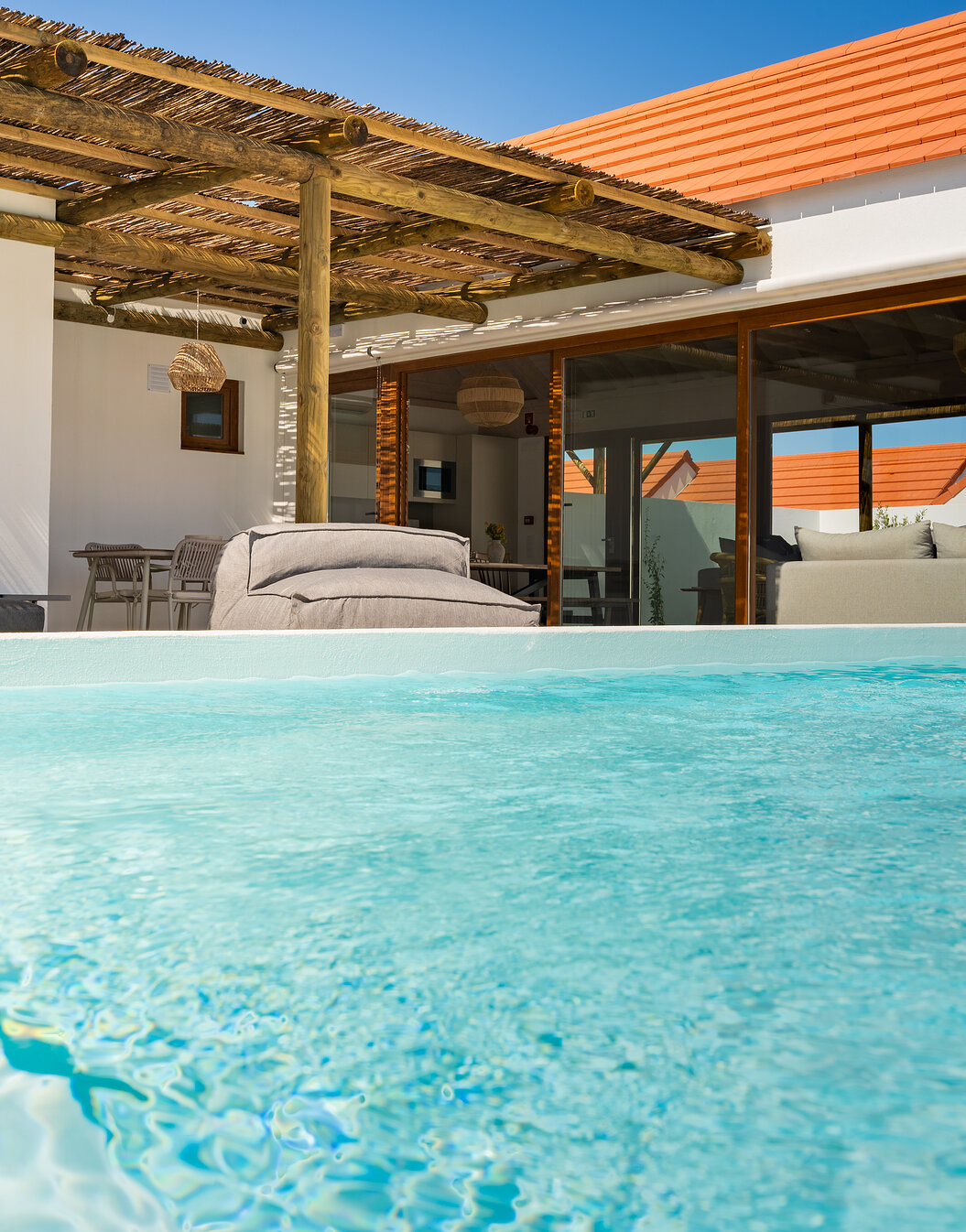 Außenbereich einer Villa im Pestana Comporta Village Residences mit einem kristallklaren blauen Pool und einer Sitzecke