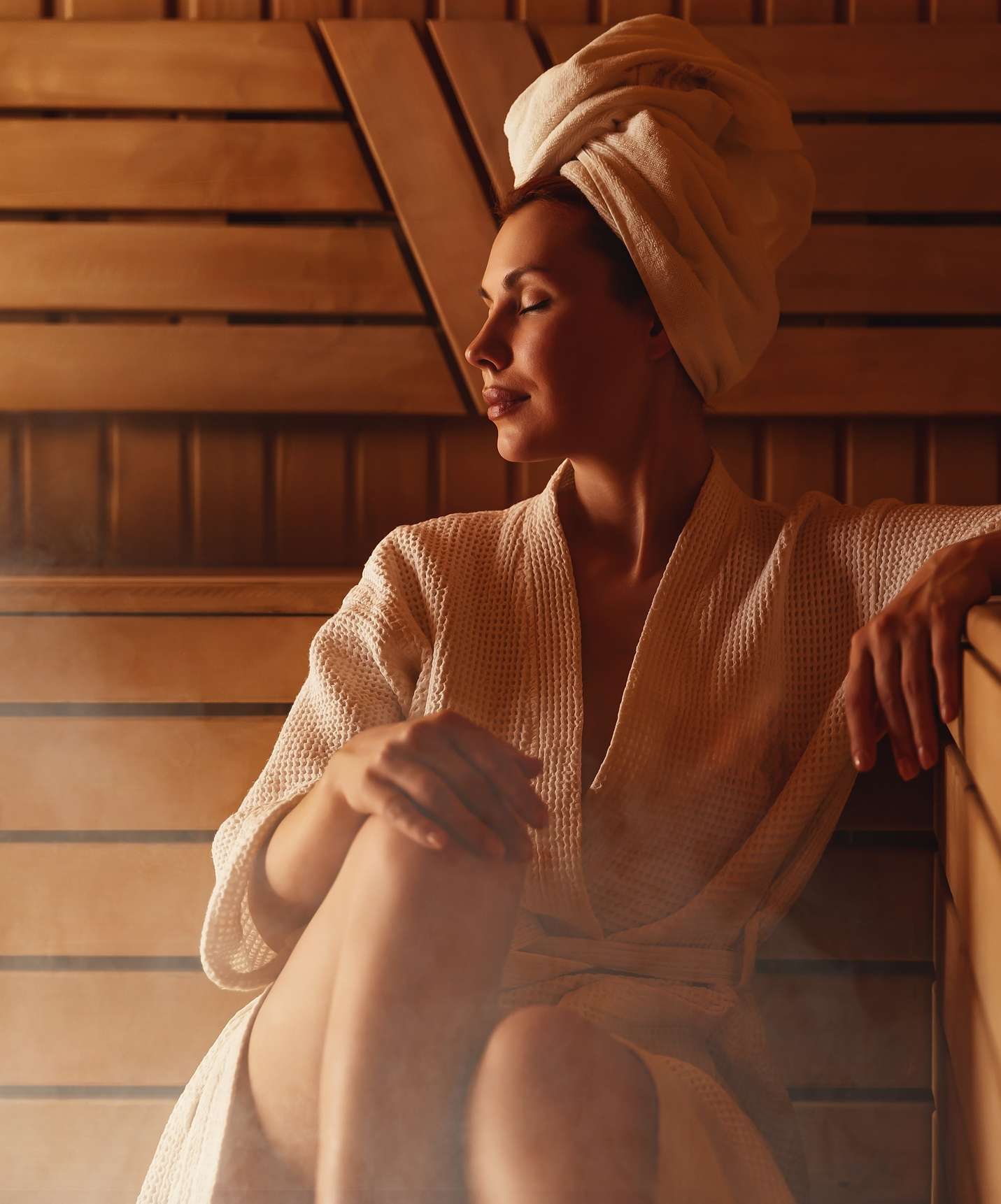 Frau entspannt in der Sauna des Pestana Tróia Eco Resort, Resort nahe der Comporta, in Bademantel und mit Handtuch