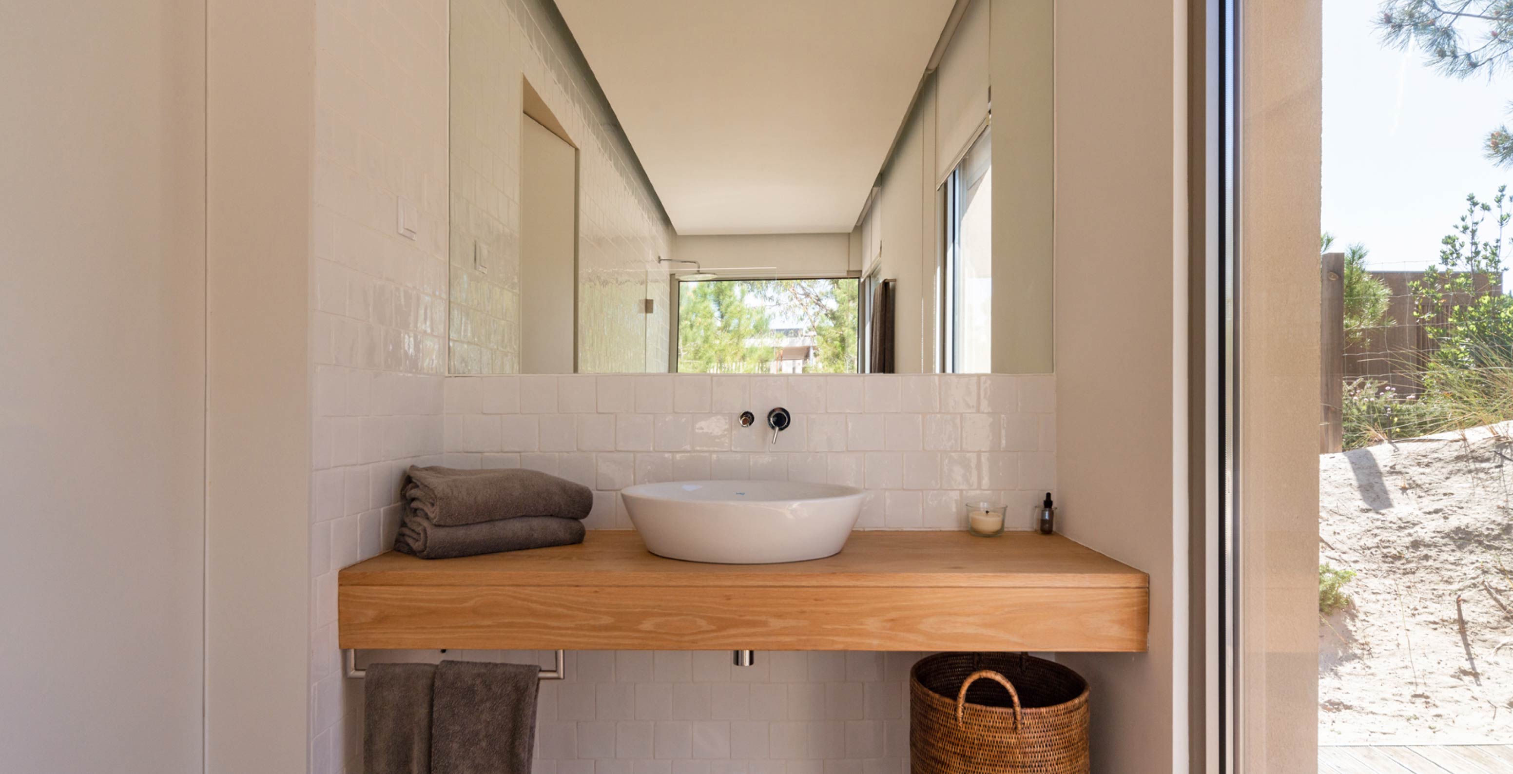 Die exklusive Villa mit Pool im Pestana Tróia Eco Resort verfügt über ein Badezimmer mit Waschbecken, Holztisch und Spiegel