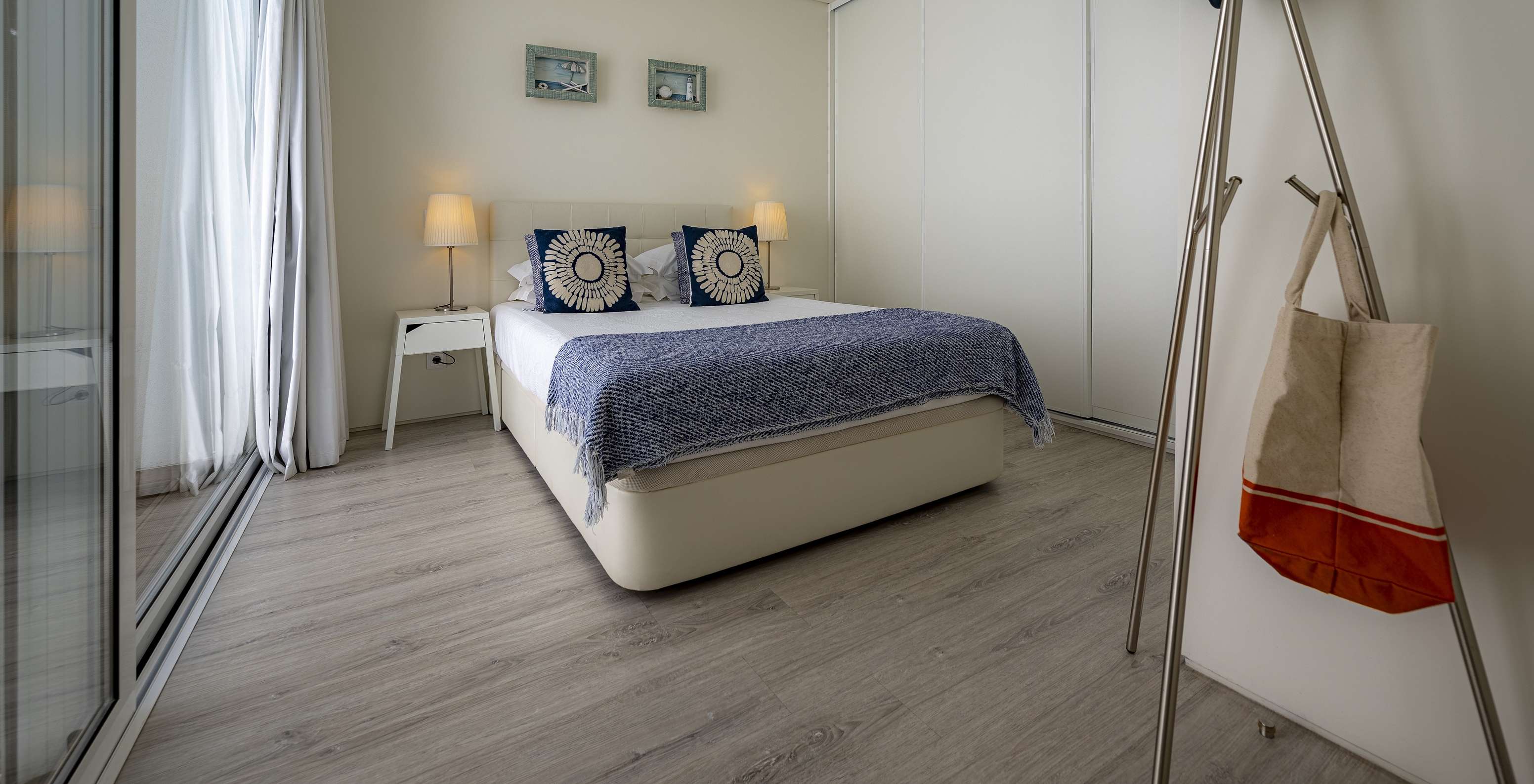 Die Green Villa im Pestana Tróia Eco Resort hat ein Doppelbett mit zwei Nachttischen und einer blauen Bettdecke