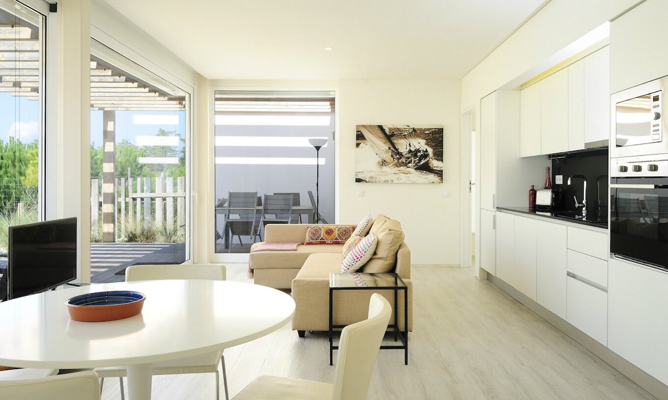 Die Green Villa T3 im Pestana Tróia Eco Resort hat einen Wohnbereich mit Küche, Sofa und Esstisch