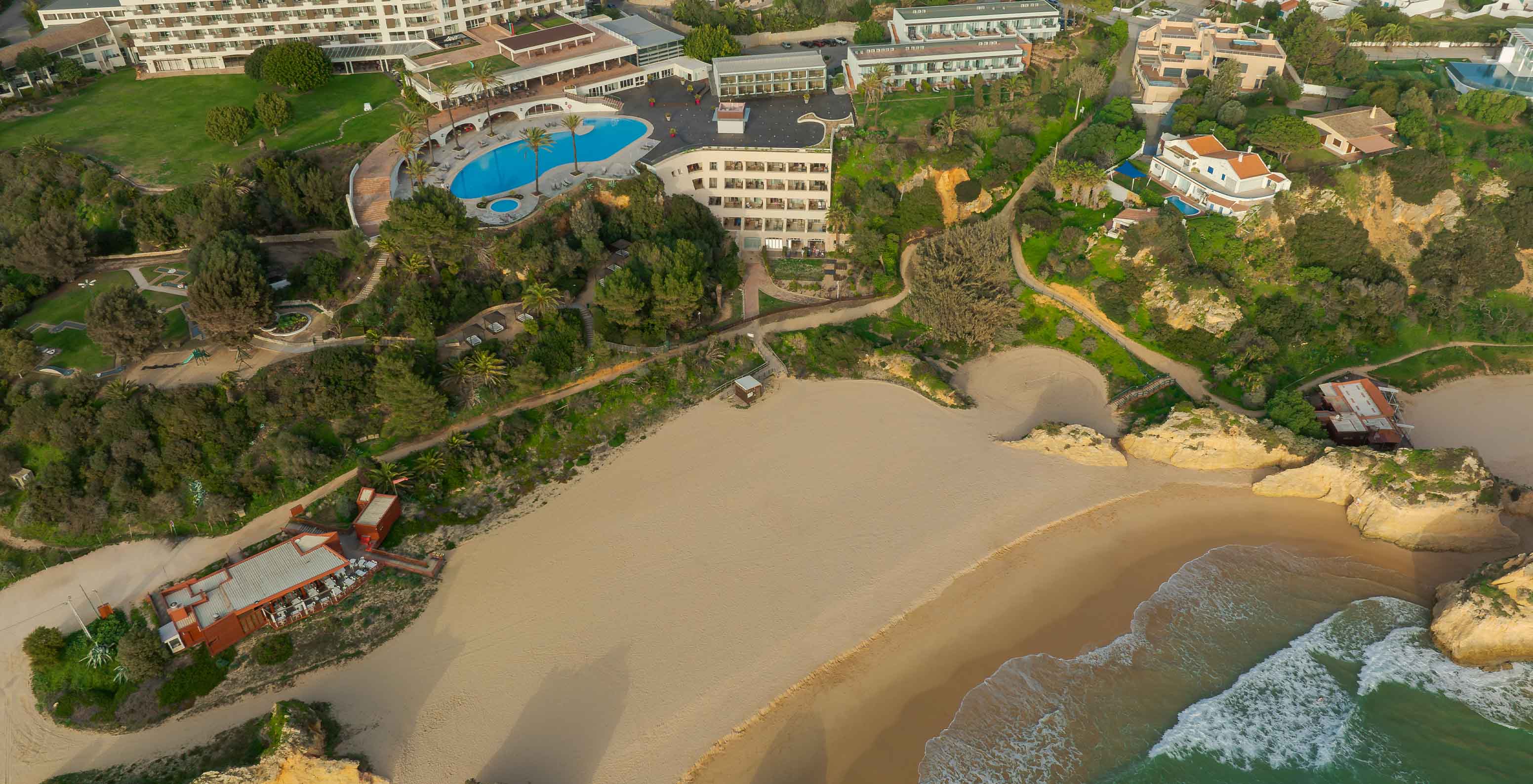Luftaufnahme des Hotels Pestana Alvor Praia mit dem Strand der Drei Brüder davor, mit Felsen, Sand und Ozean