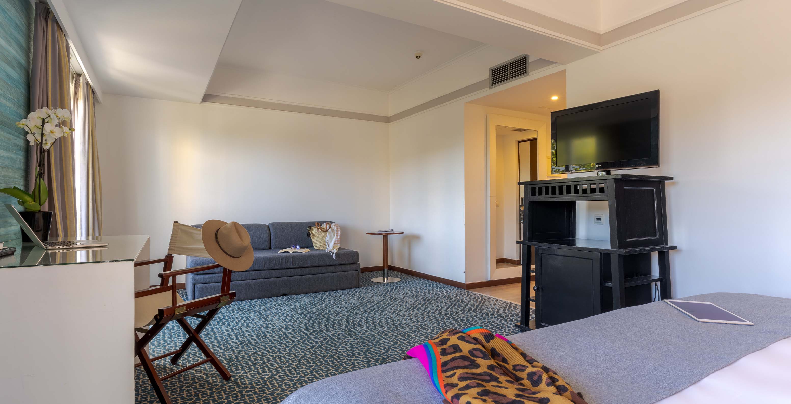 Das Superior im Pestana Alvor Praia hat ein Doppelbett, ein schwarzes Möbelstück mit Fernseher und ein Sofa