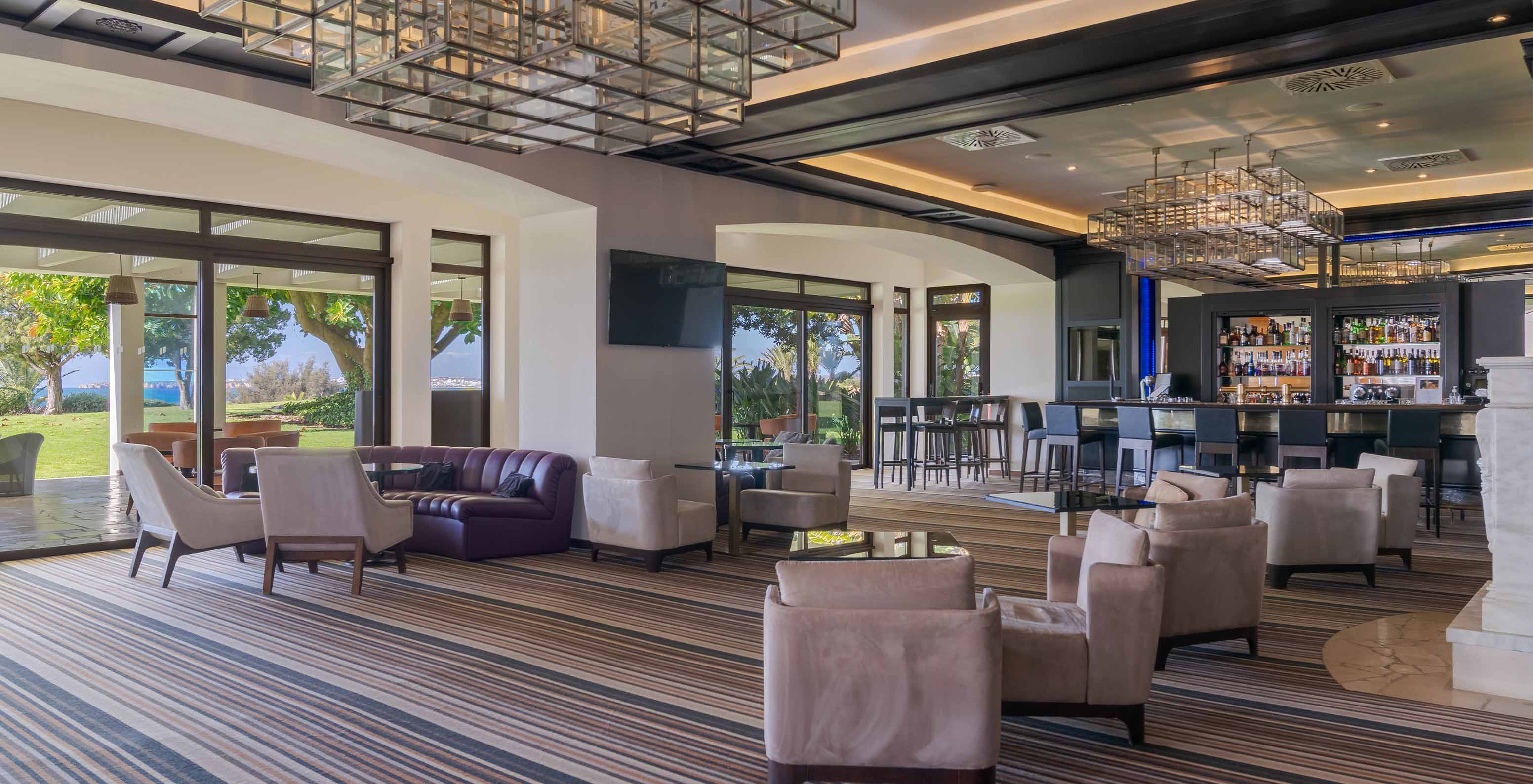 Die Bar D Henrique, im Hotel in der Algarve, hat Sofas und Sessel für Getränke mit Blick auf das Meer und den Garten