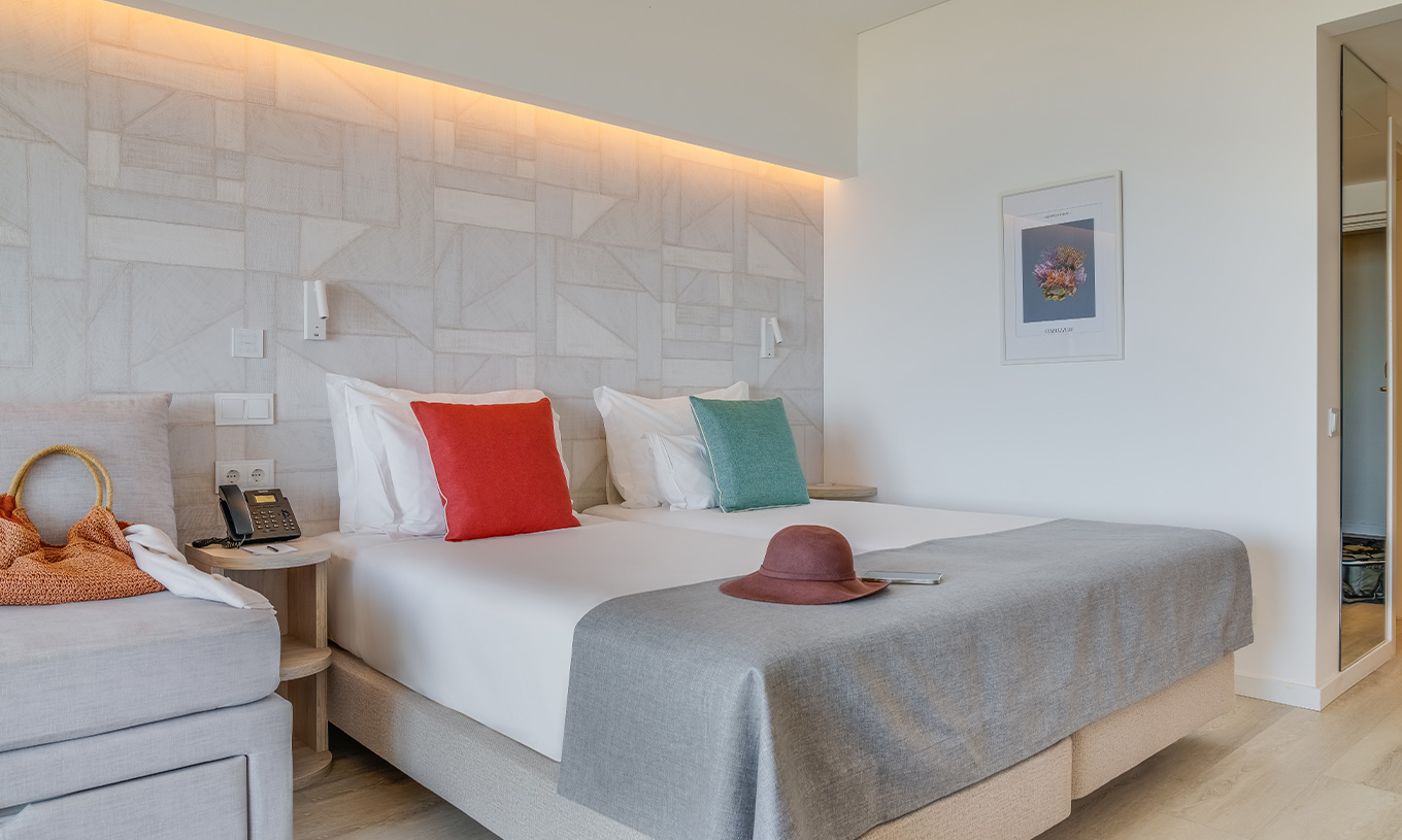 Das Familienzimmer im Pestana Blue Alvor Beach hat zwei Einzelbetten, ein Bild und einen großen Spiegel an der Wand