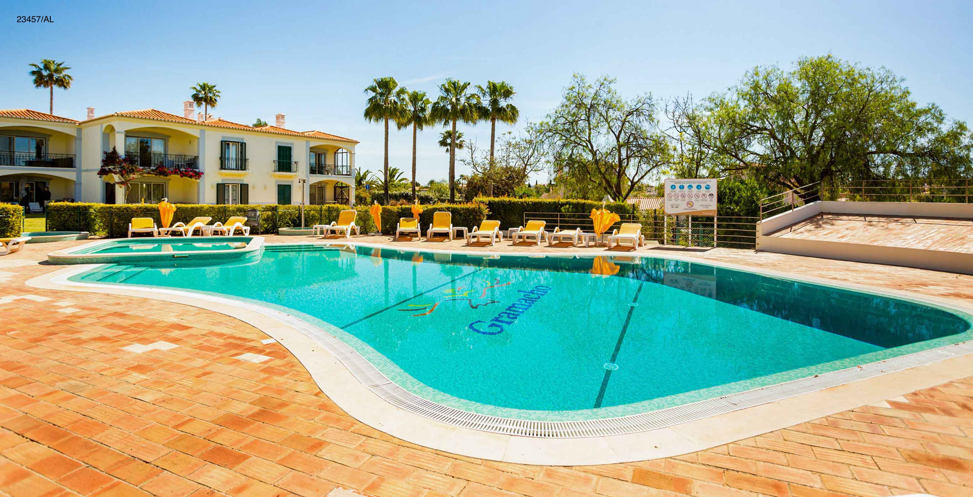 Die Wohnung Pestana Carvoeiro Golf T3 Standard hat einen Außenbereich mit Pool und gelben Liegestühlen