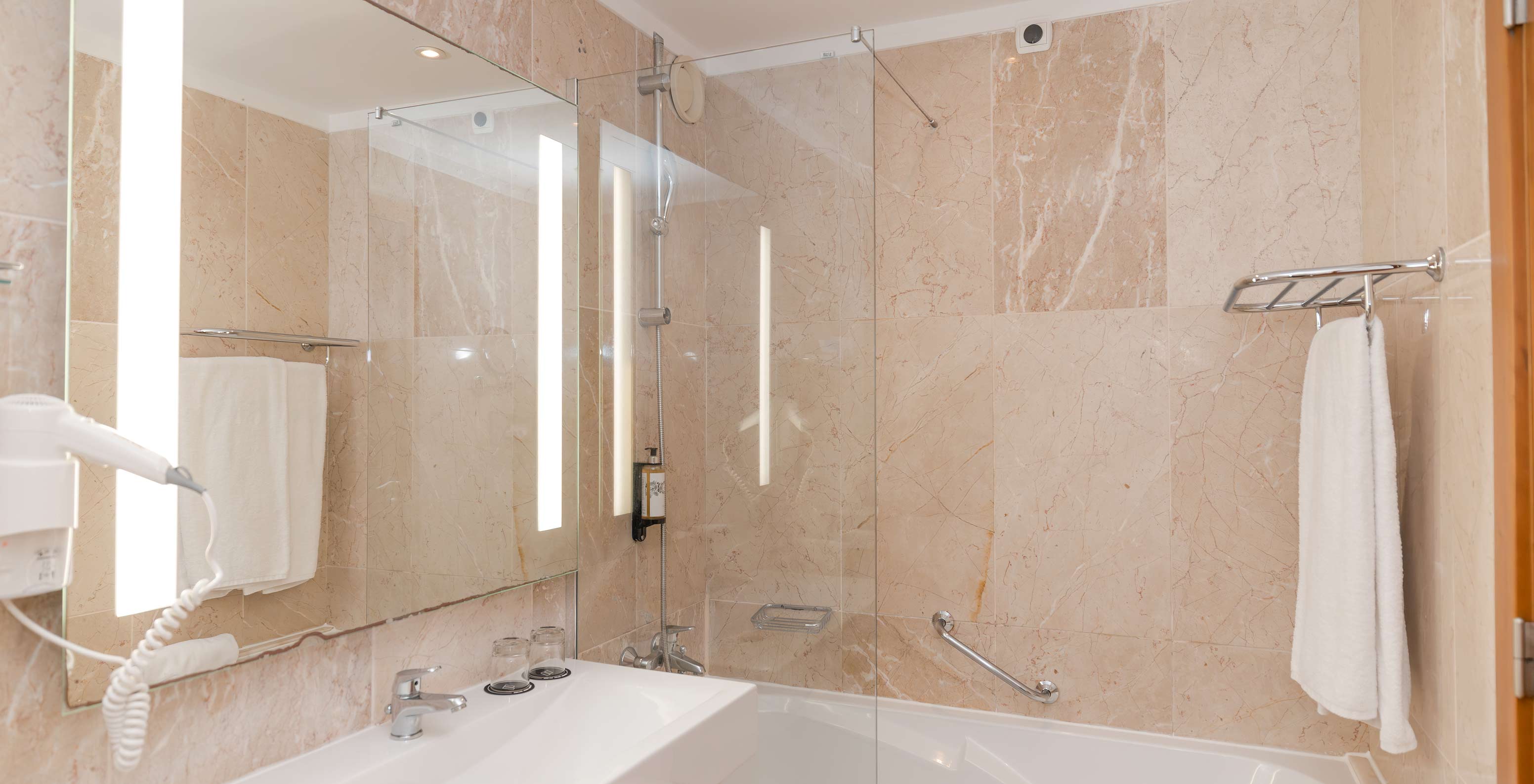 Suite Meerblick Pestana Viking hat ein Badezimmer mit Waschbecken, Spiegel und Badewanne