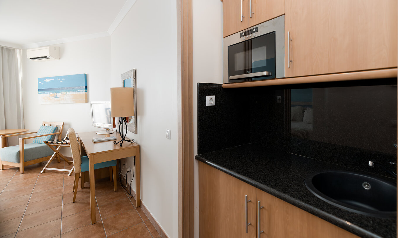 Das Deluxe Meerblick im Pestana Viking hat einen Schreibtisch und eine kleine Küche mit Mikrowelle und Schränken