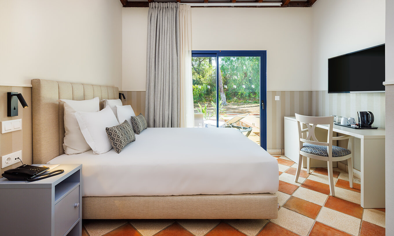 Klassik Gartenblick Pestana Vila Sol - Vilamoura hat ein Doppelbett, einen Schreibtisch mit Stuhl und ein Fenster mit Balkon