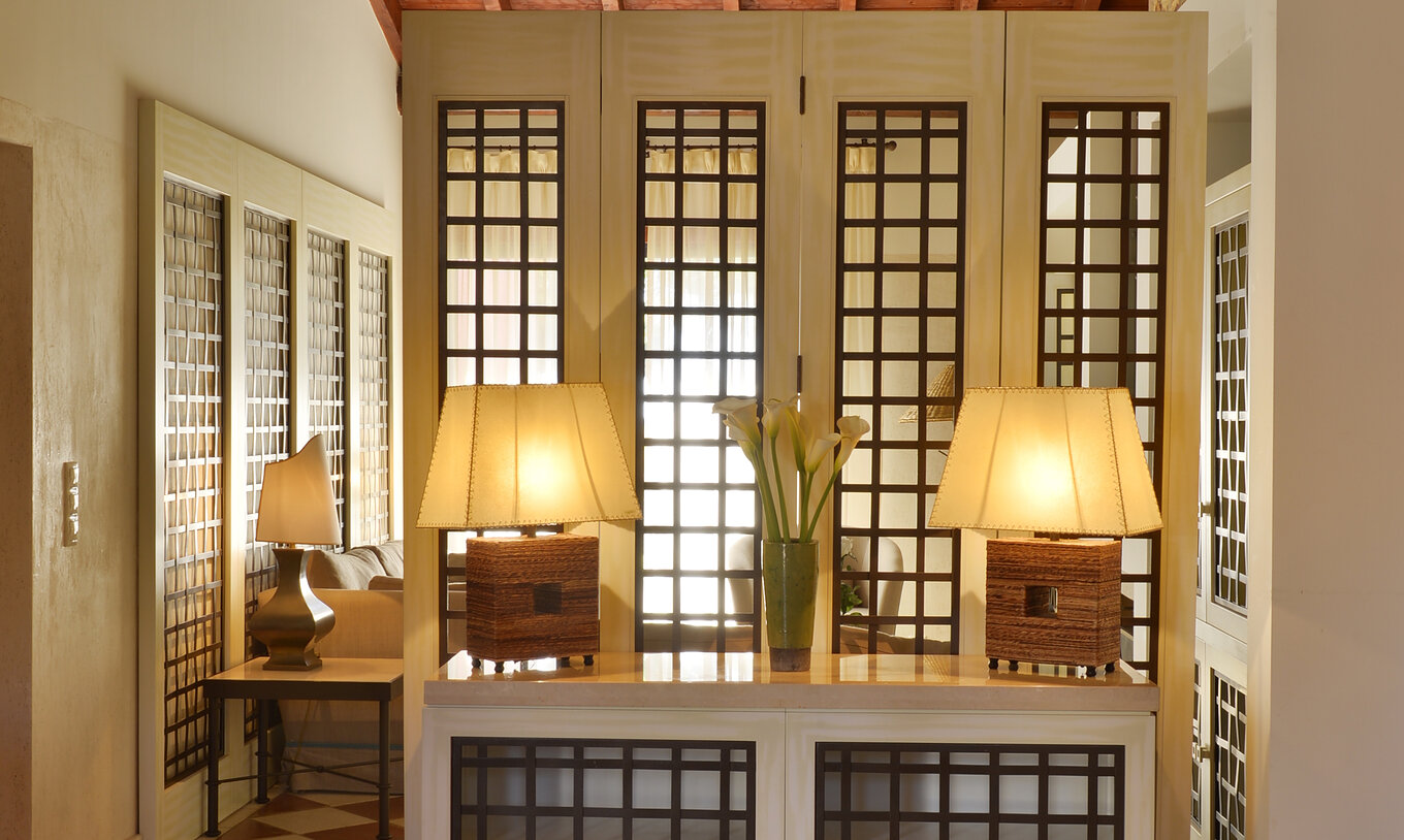 Die Gartenblick Suite Vila Sol im Pestana Vila Sol - Vilamoura hat einen Eingang mit einem Tisch, zwei Lampen und einer Kanne