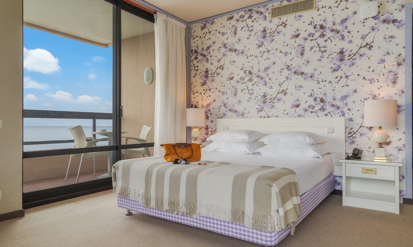 Das Standard Meerblick Zimmer im Pestana Bahia Praia hat ein Doppelbett mit vier Kissen und einen Balkon mit Meerblick