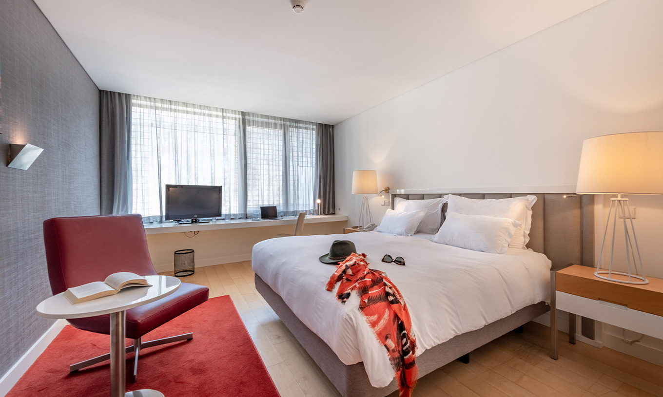 Das Classic Zimmer im Pestana Cidadela Cascais hat ein Doppelbett, Fernseher, roten Teppich und ein großes Fenster