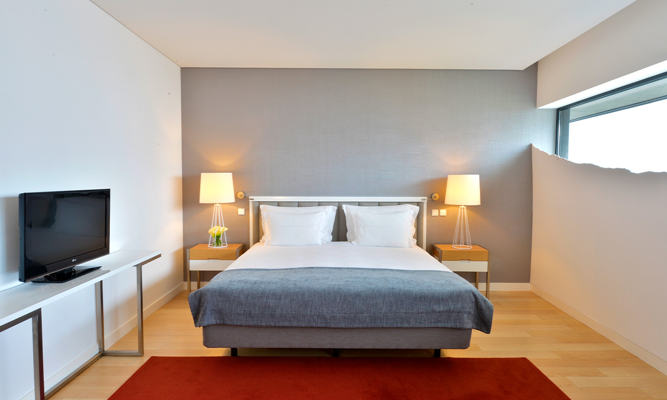 Das Double Superior Zimmer im Pestana Cidadela Cascais hat ein Doppelbett, zwei Nachttische und einen roten Teppich