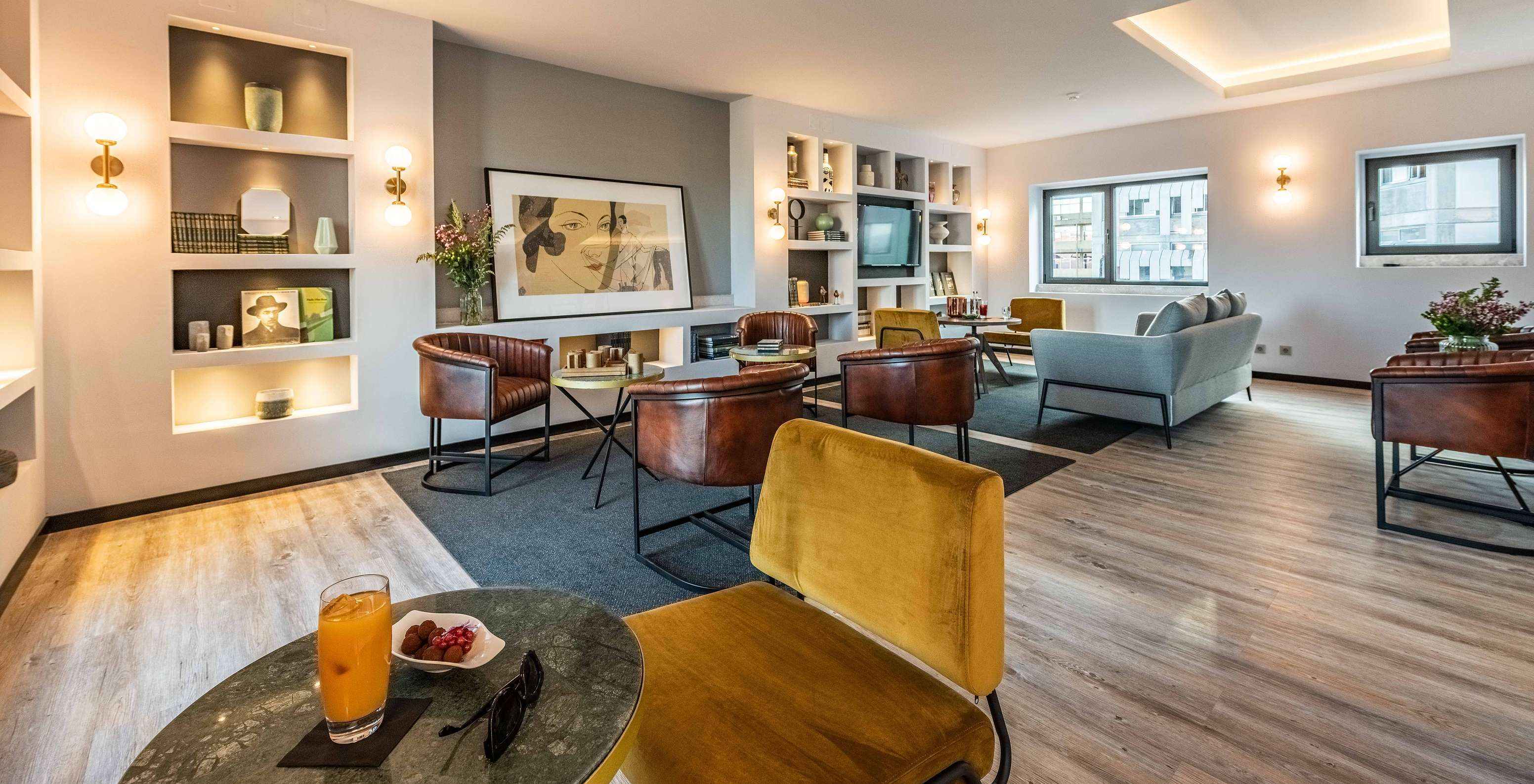 Lounge mit Sofas, Stühlen, Tischen, Bildern, Fernseher, Teppichen und Dekorationsgegenständen mit Stadtblick