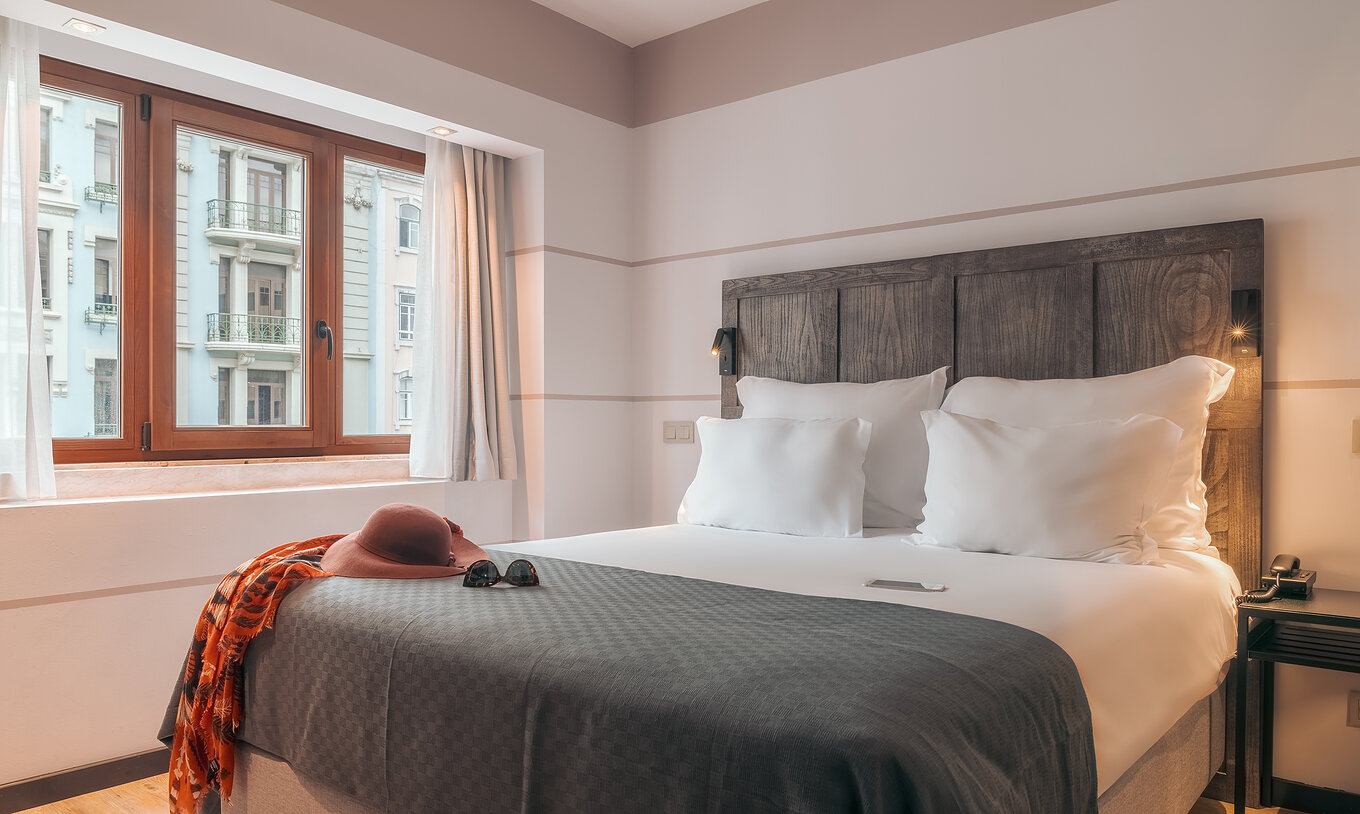 Das Double Classic im Pestana Lisboa Vintage hat Doppelbett mit Kopfteil, grauer Decke und Holzfenster