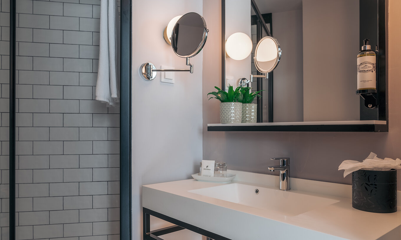 Das Double Superior im Pestana Lisboa Vintage hat Bad mit Waschbecken, zwei Spiegeln und seitlicher Dusche