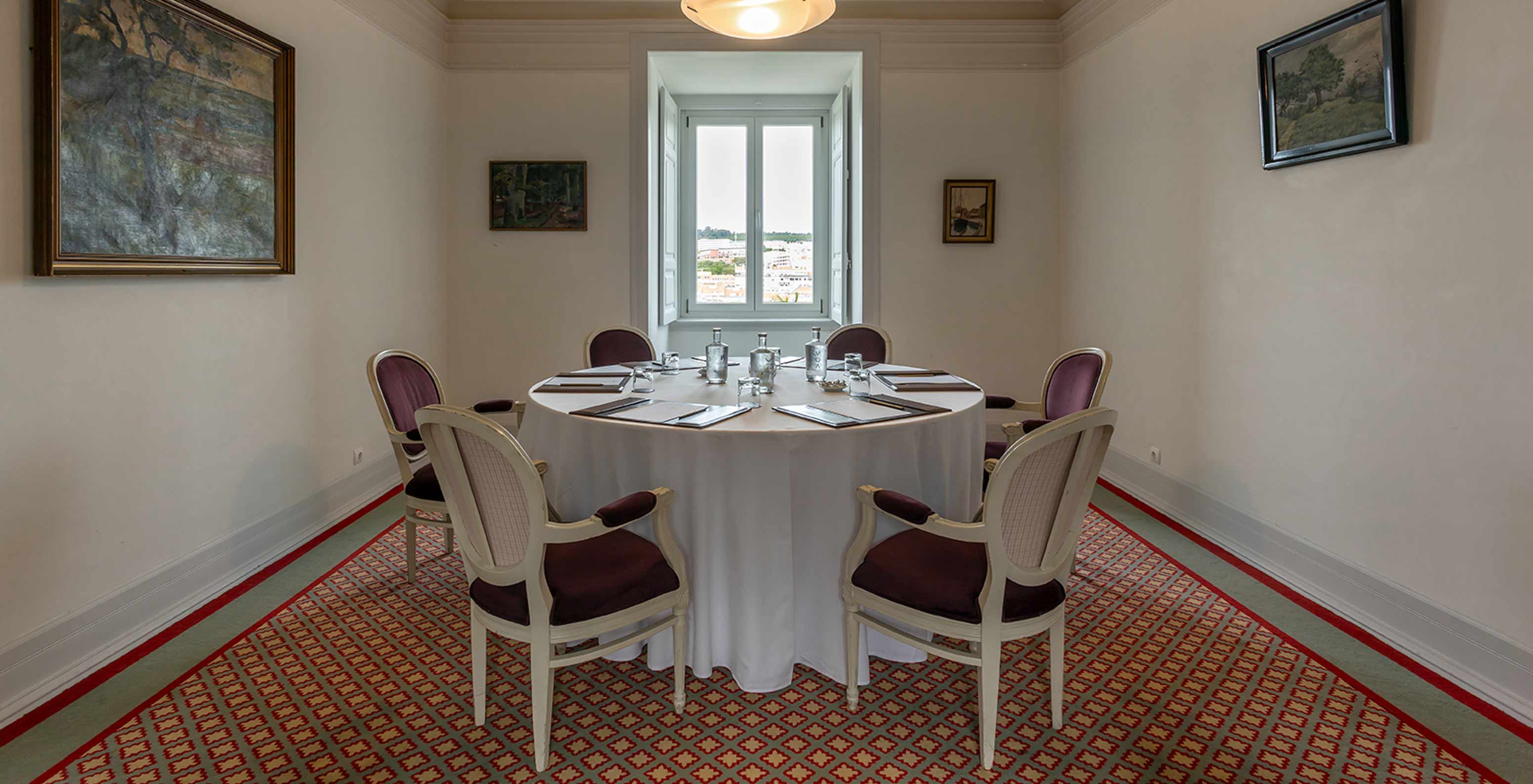 Das Pestana Palace Lisboa hat einen Besprechungsraum mit rundem weißen Tisch und lila Stühlen	
