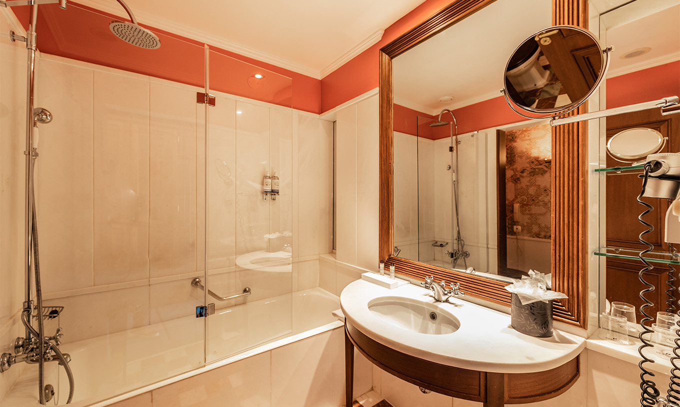 Das Premium Balkon Zimmer im Pestana Palace Lisboa hat ein Bad mit Badewanne, Waschbecken und Spiegel