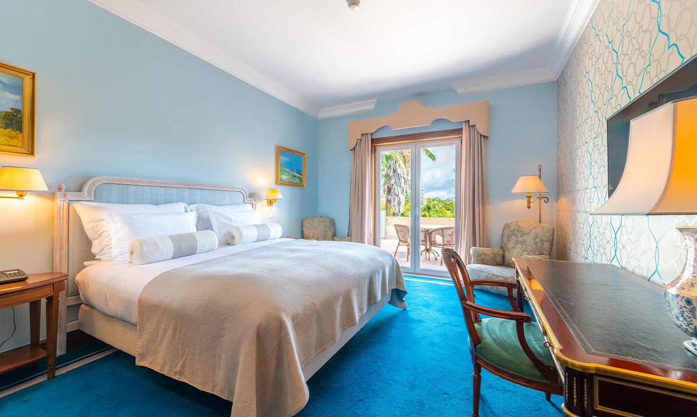 Das Premium Balkon Zimmer im Pestana Palace Lisboa hat ein Doppelbett, hellblaue Wände und ein Fenster