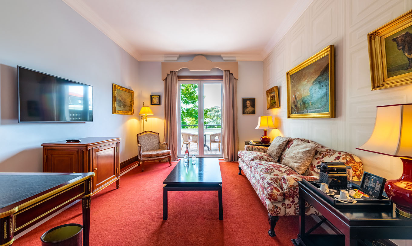 Die Collection Suite im Pestana Palace Lisboa hat ein Zimmer mit Sofa, Fernseher und Fenster mit Balkon