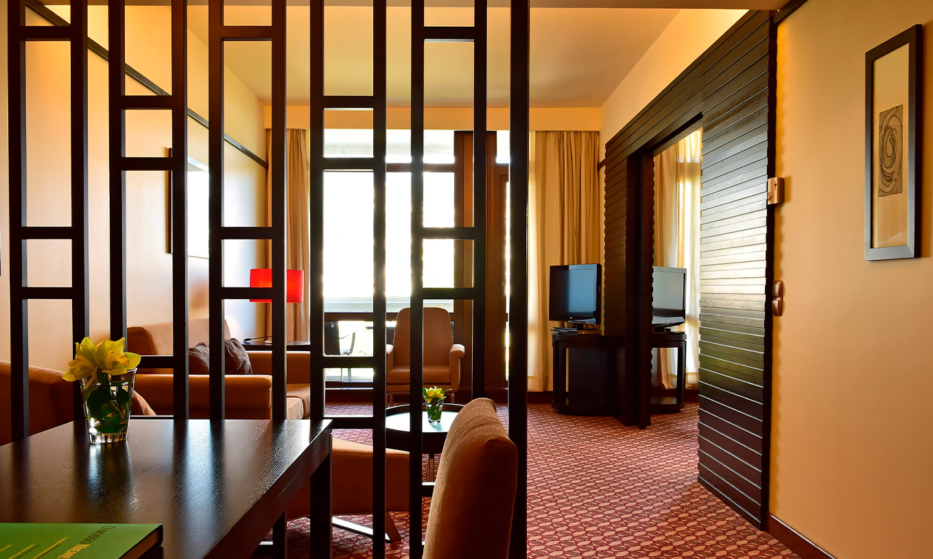 Die Suite mit seitlichem Meerblick im Pestana Casino Park hat einen Sitzbereich mit Sofa und Chaiselongue