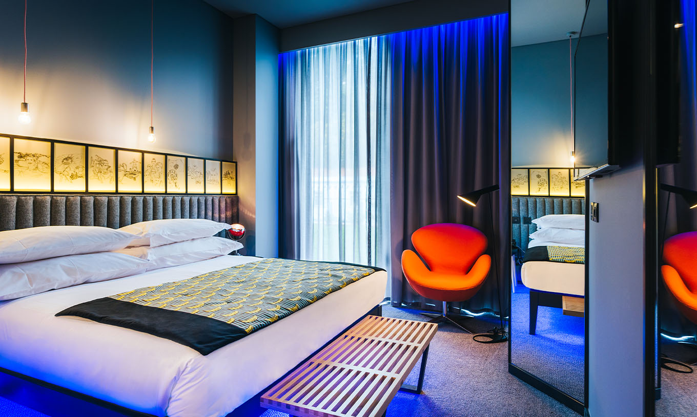 Das CR7 Zimmer im Pestana CR7 Funchal hat einen großen Raum mit Doppelbett, einer Bank und einem bequemen Stuhl