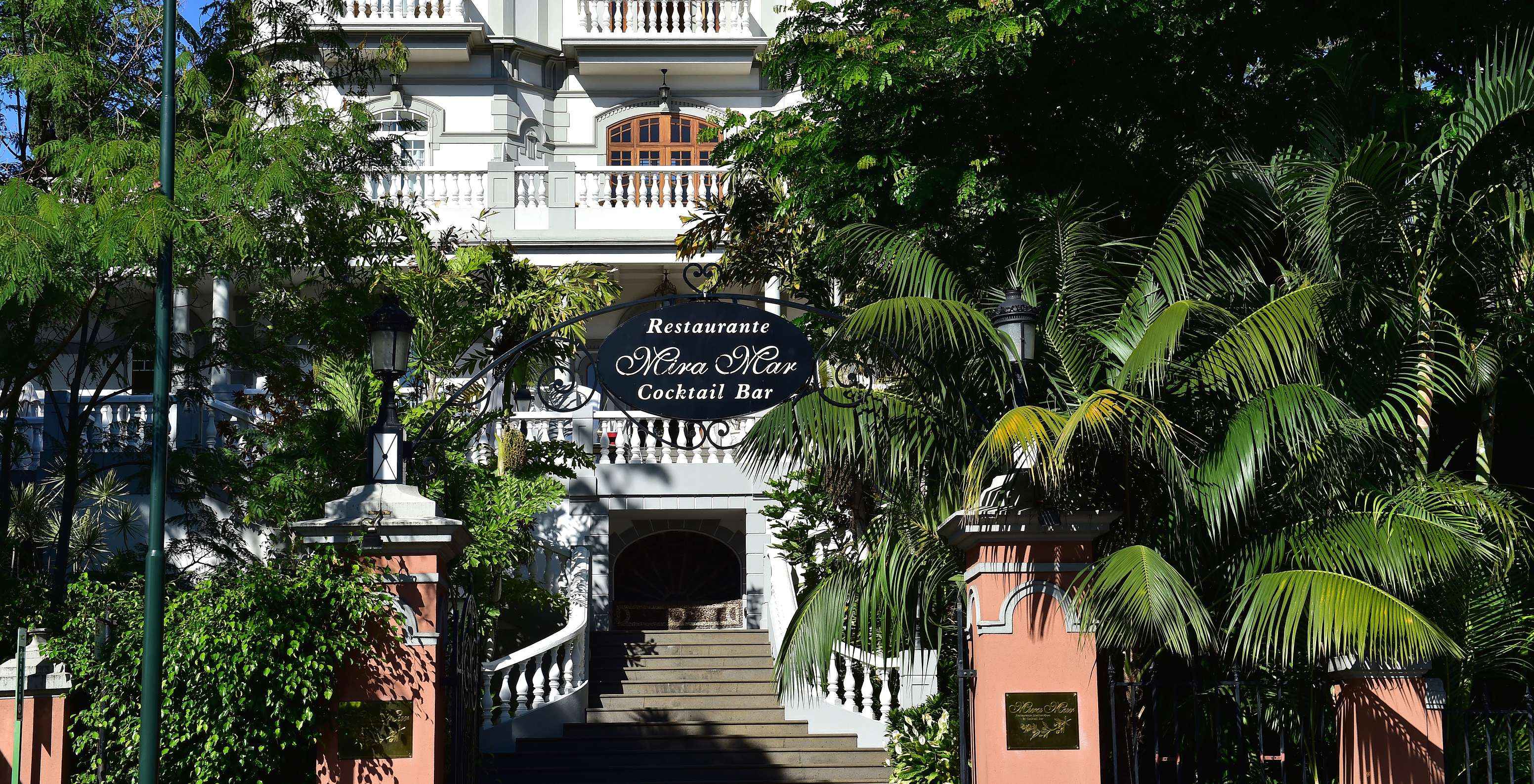 Fassade des Restaurants der Quinta Miramar, ein imposantes weißes Gebäude inmitten der Vegetation, ideal für Veranstaltungen
