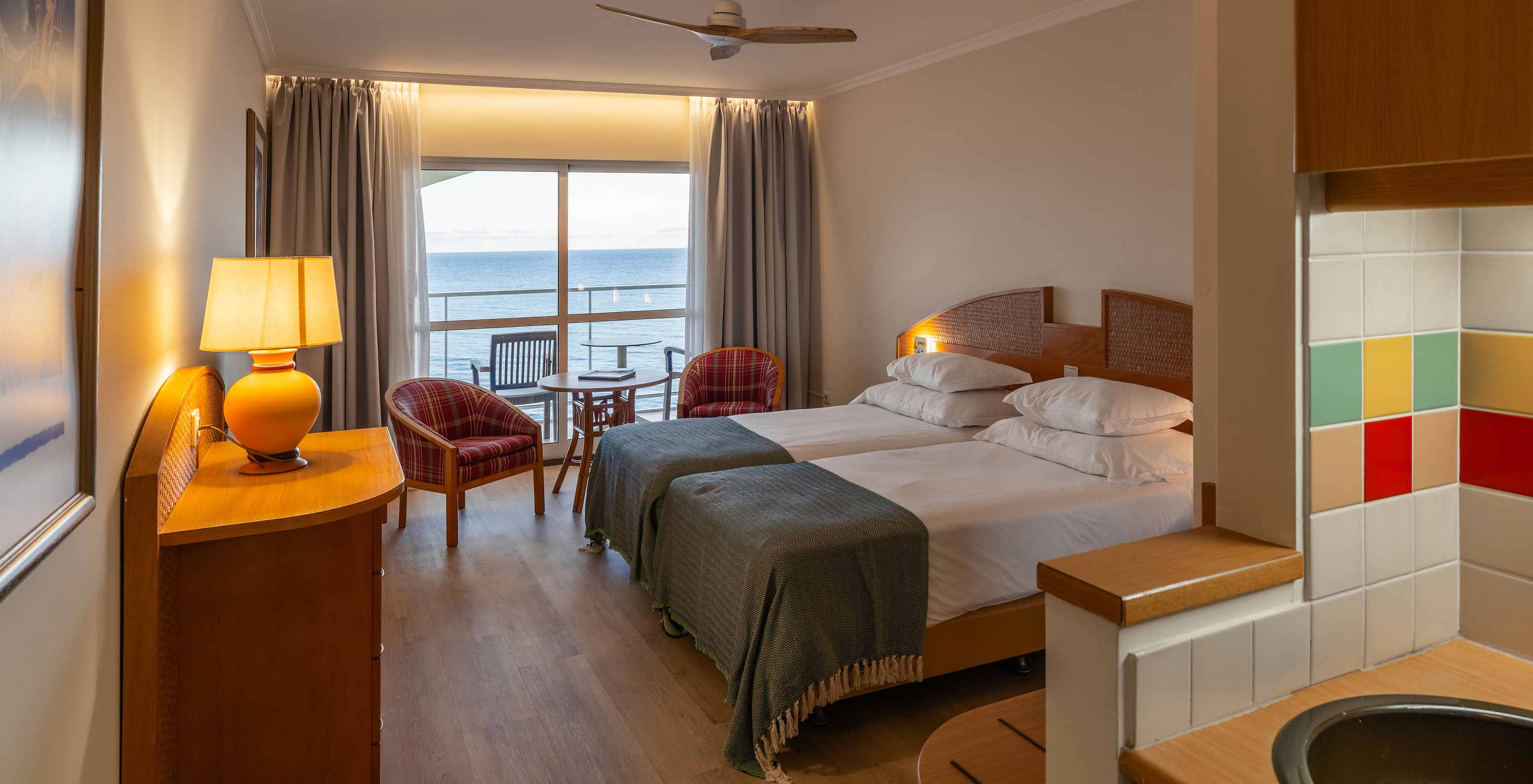 Das Superior Sea View im Pestana Ocean Bay All Inclusive verfügt über ein Doppelbett, zwei Sessel und einen Balkon