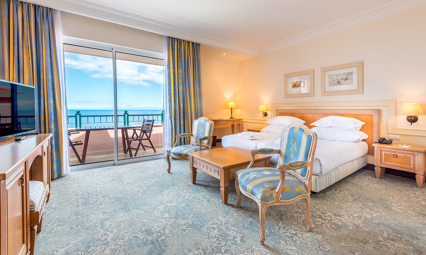 Das Deluxe Superior Zimmer im Pestana Royal All Inclusive hat ein Doppelbett und einen Sessel