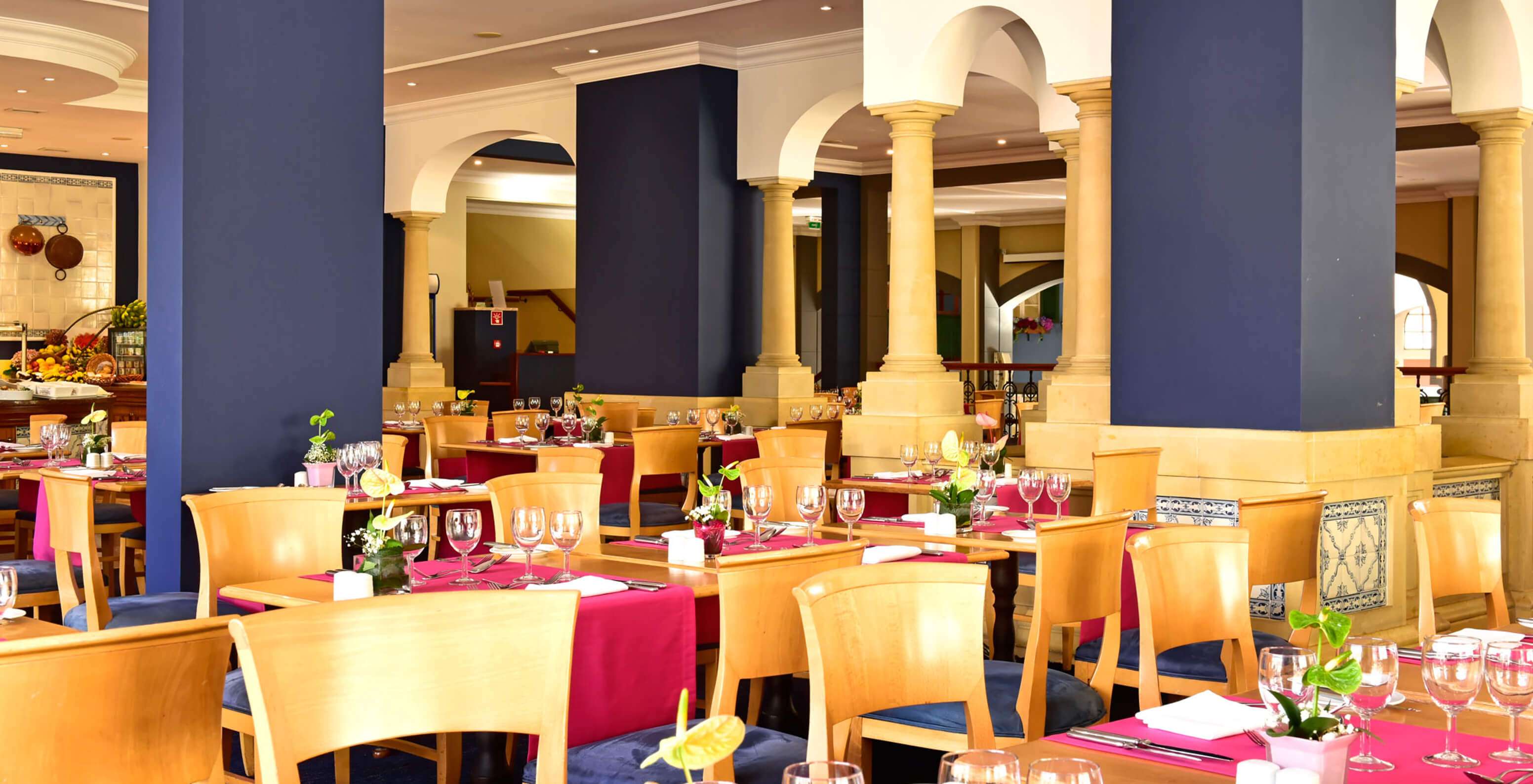 Das Restaurant A Vila, Romantisches Hotel in Funchal, Madeira hat mehrere Tische mit Holzstühlen