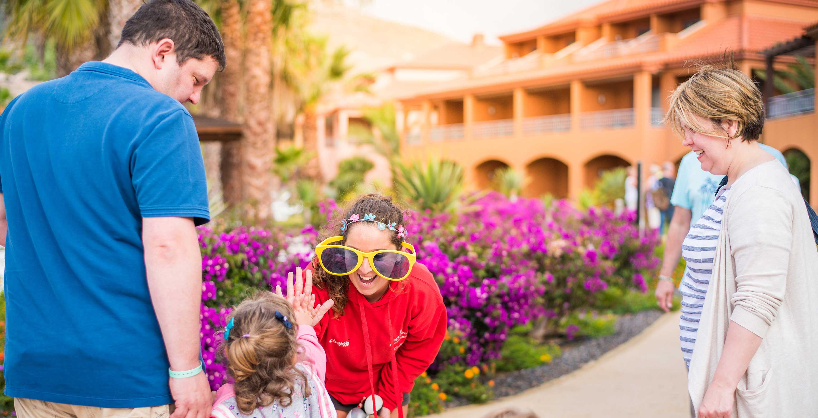 Familie hat Spaß im Pestana Porto Santo, große Sonnenbrillen, violette Blumen an einem sonnigen Tag