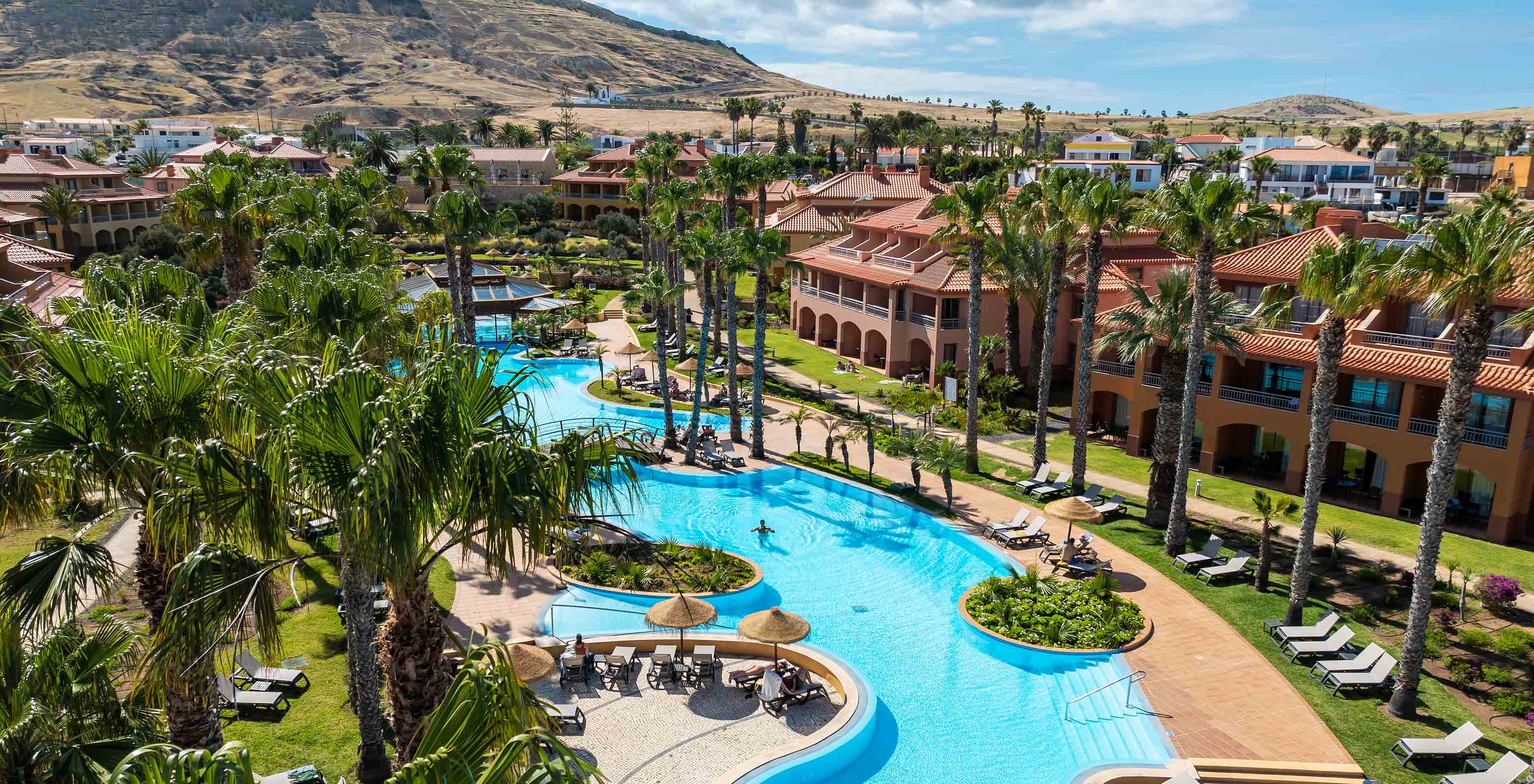 Anordnung der Villen des Pestana Porto Santo All Inclusive, umgeben von Vegetation und mit dem Außenpool in der Mitte